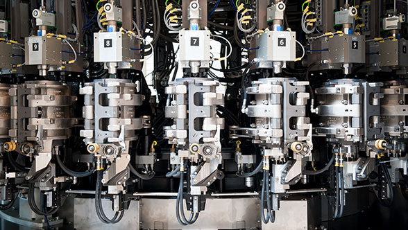 Blow molder equipment forming plastic bottles on an industrial production line