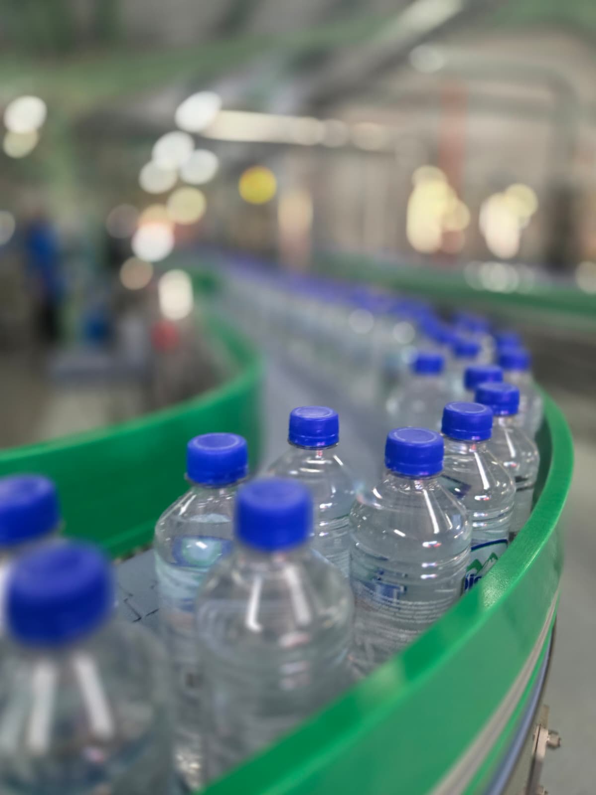 Botellas de agua en una línea de producción, representando el proyecto de modernización de la línea de bebidas